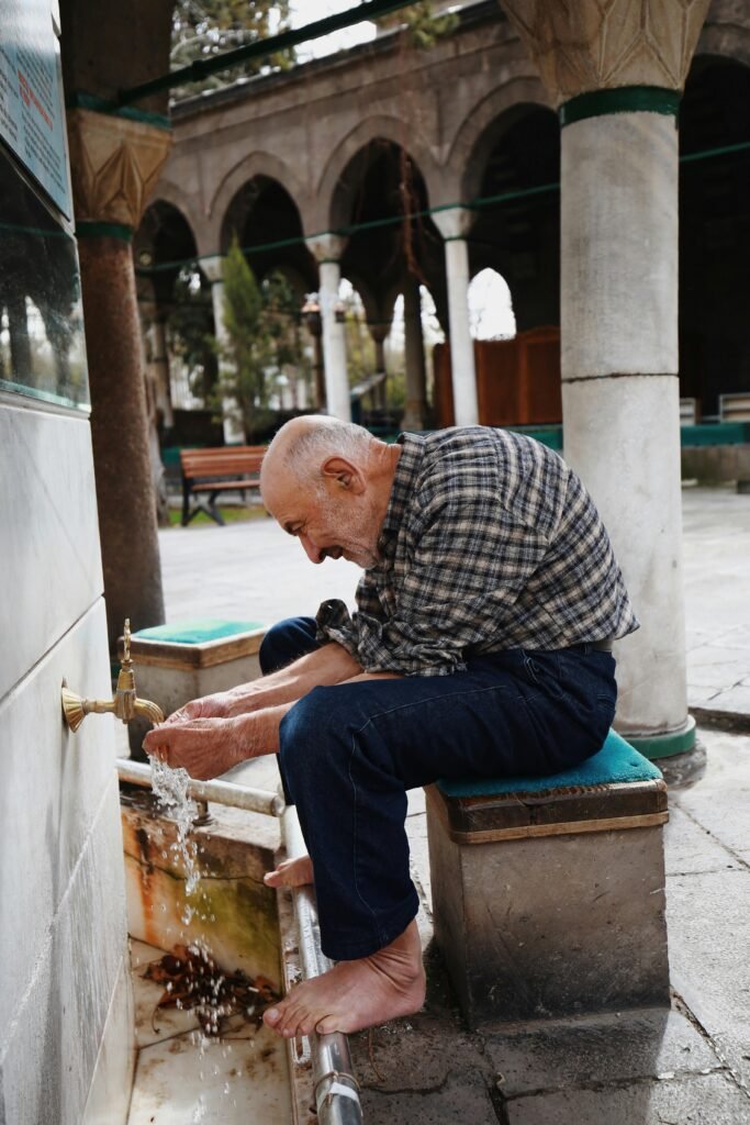 un homme assit qui fait ses grandes ablutions